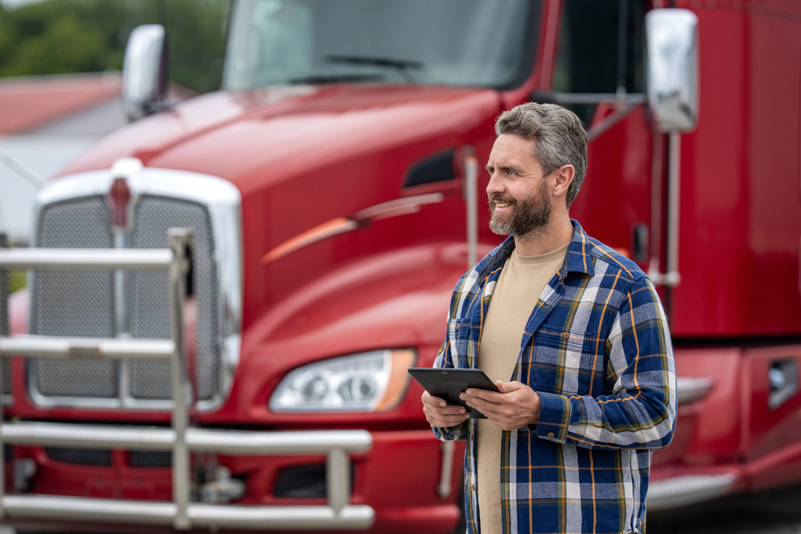 Man use tablet to configure equipment. Automated logistics online internet. Trucker driver man with tablet, banner. Truck maintenance. Hispanic trucker at truck. Using tablet chatting with customer.