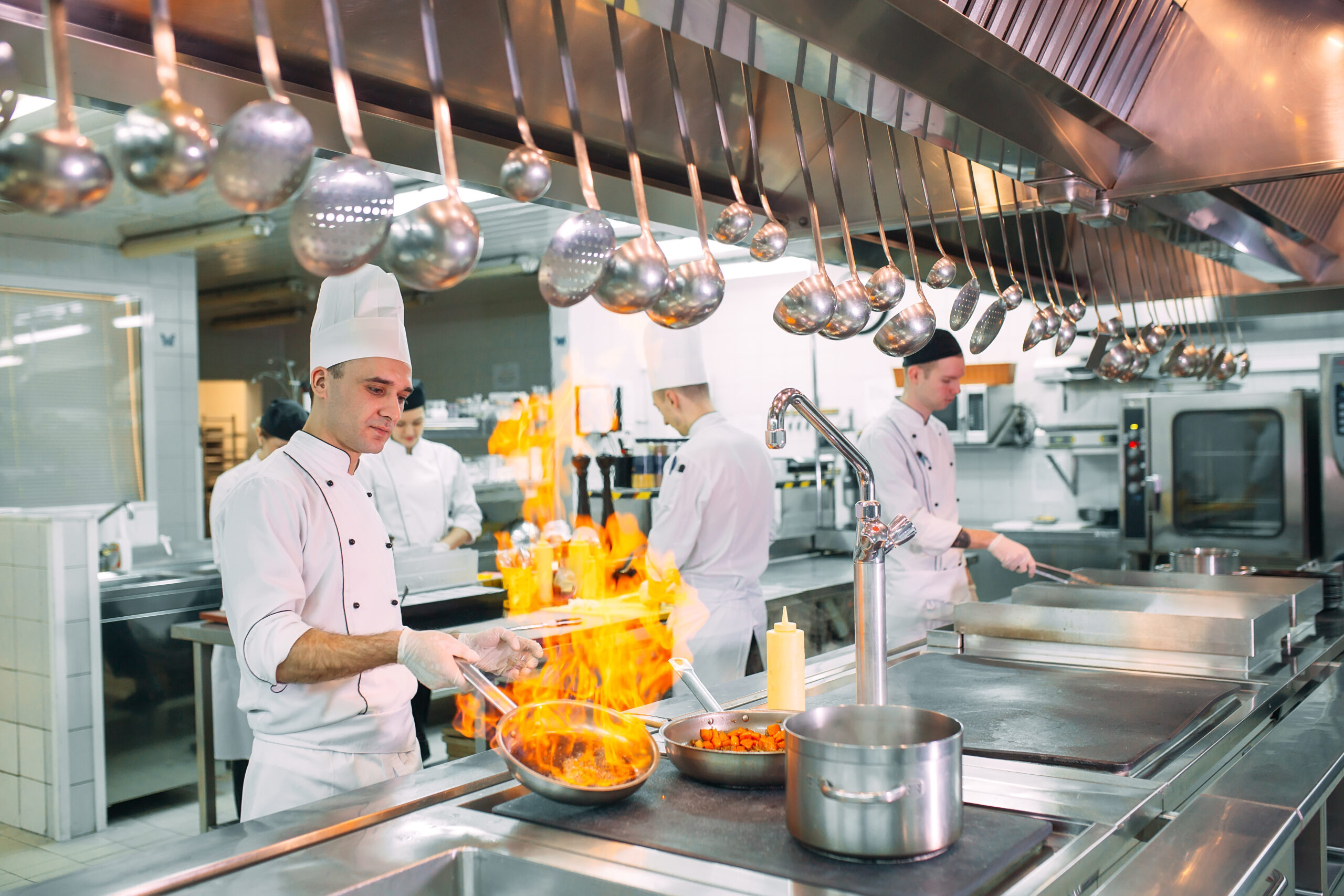 Modern kitchen. Cooks prepare meals on the stove in the kitchen of the restaurant or hotel. The fire in the kitchen