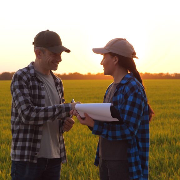 Handshaking in agriculture. two farmers agreement for teamwork in agricultural field. Handshake in sign of teamwork in green wheat field. agricultural business