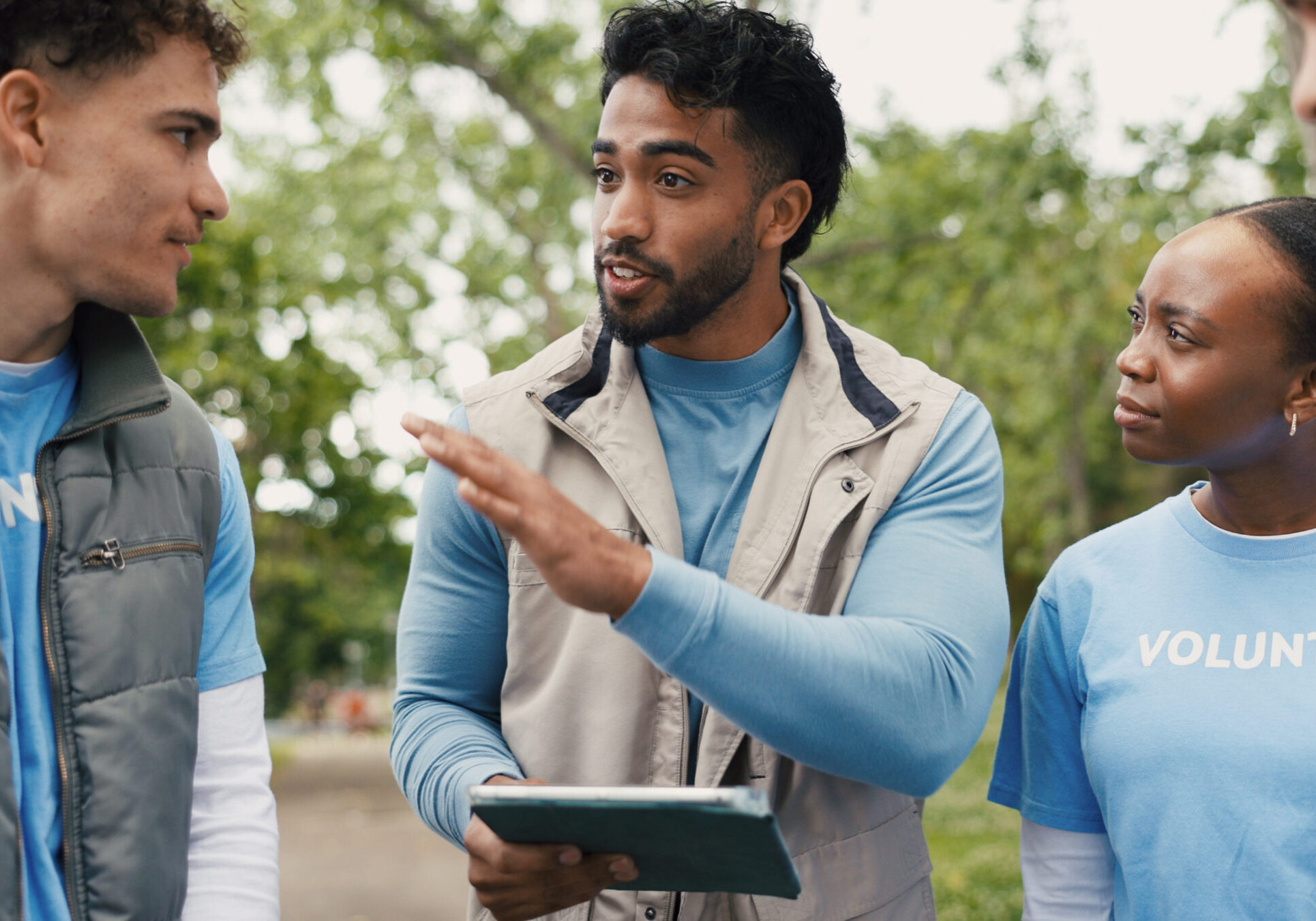 Volunteer, tablet and team outdoor for meeting, planning and community service discussion. Tech, people and group with charity worker at park for coordination, donation project and non profit leader.