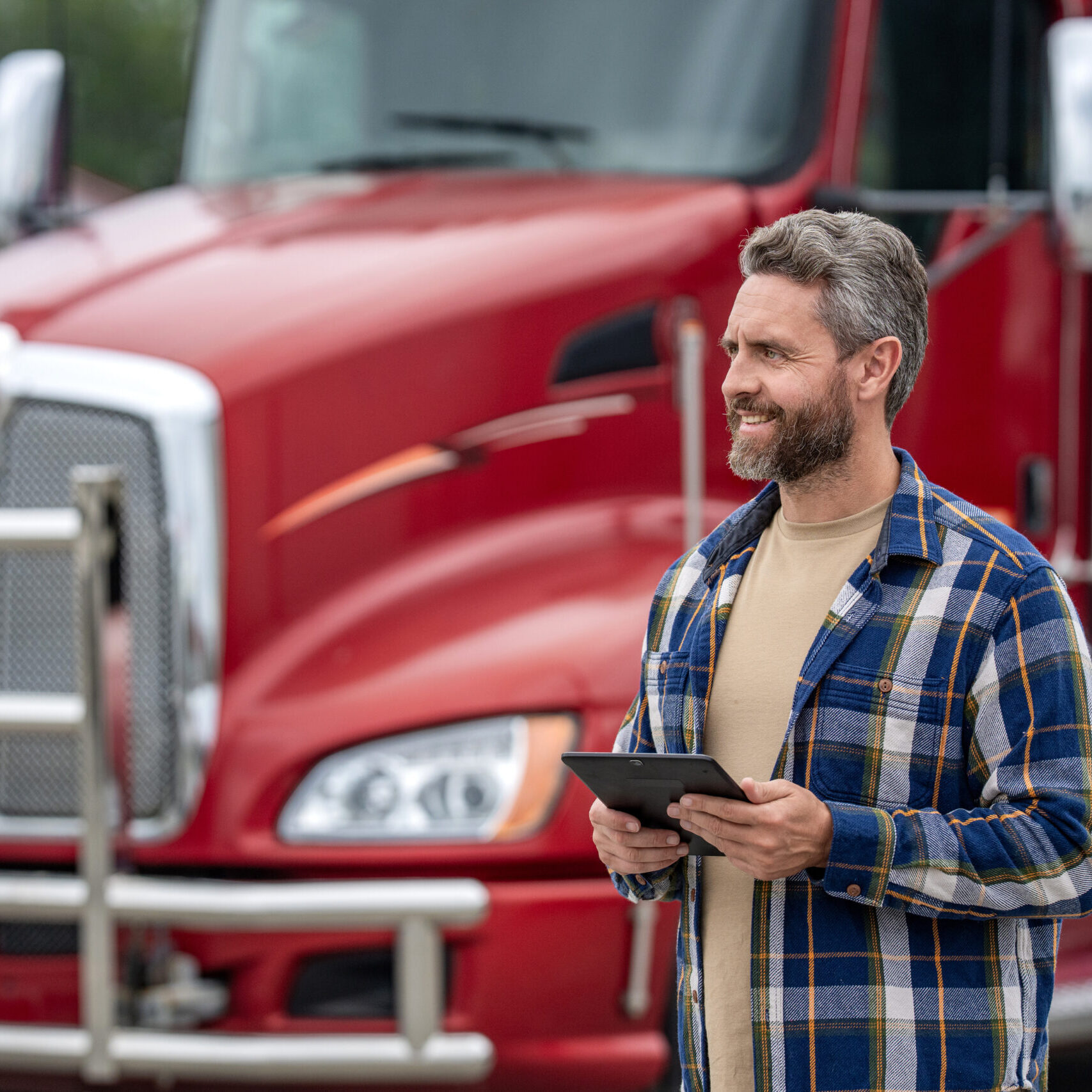 Man use tablet to configure equipment. Automated logistics online internet. Trucker driver man with tablet, banner. Truck maintenance. Hispanic trucker at truck. Using tablet chatting with customer.