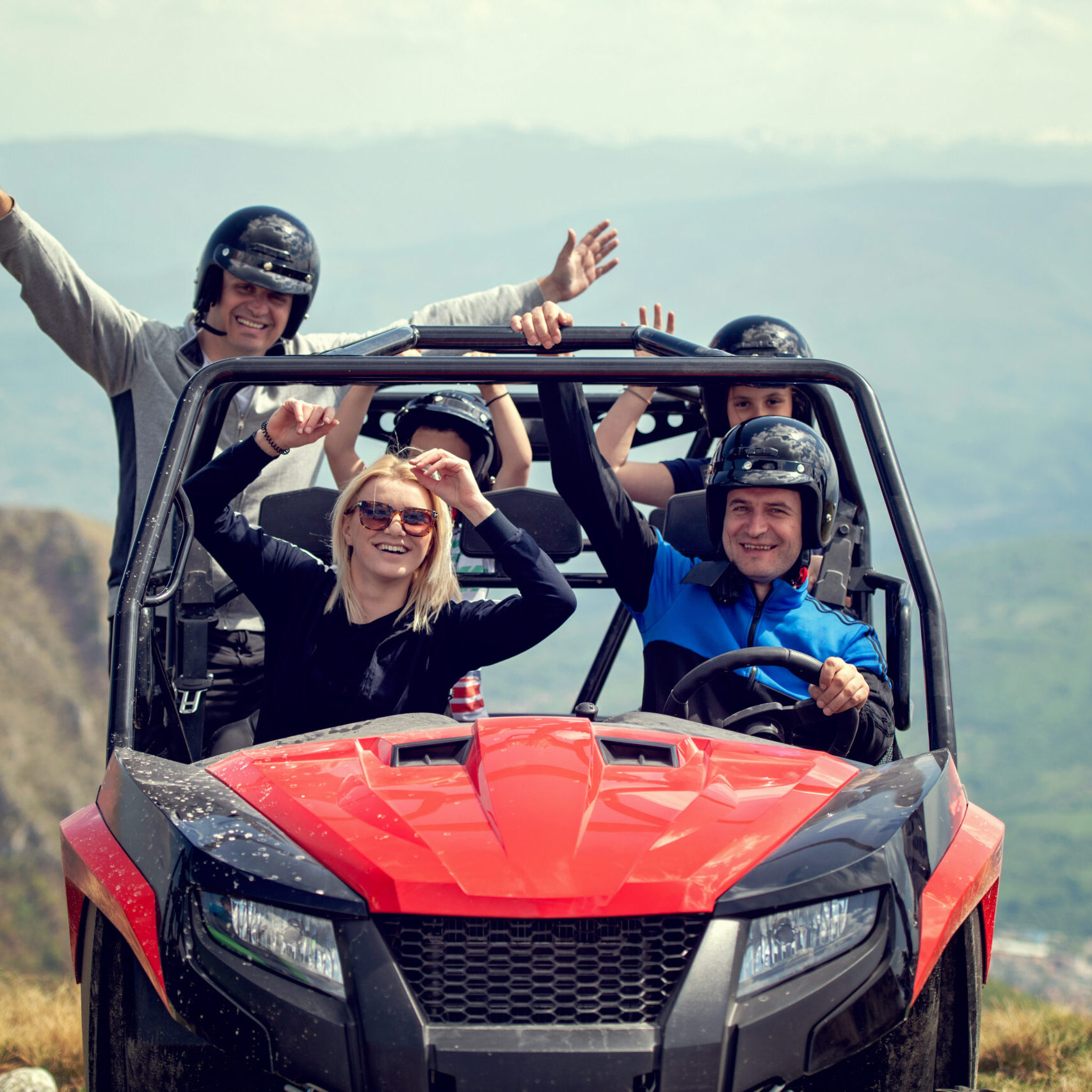 Friends driving off-road with quad bike or ATV and UTV vehicles.