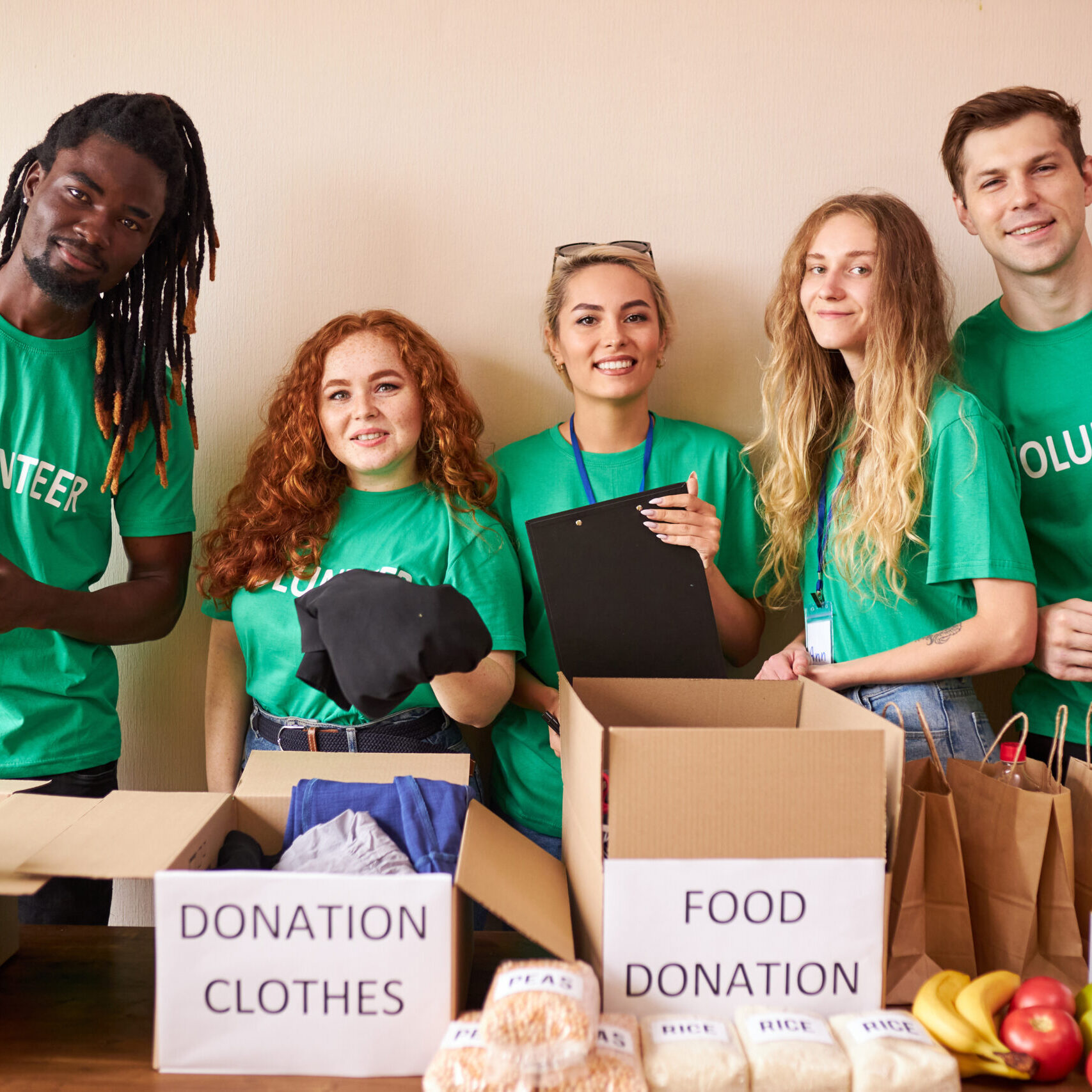 diverse volunteers packing, collecting humanitarian aid in donation box. multi-ethnic group of people working in charitable foundation helping in crises and homeless