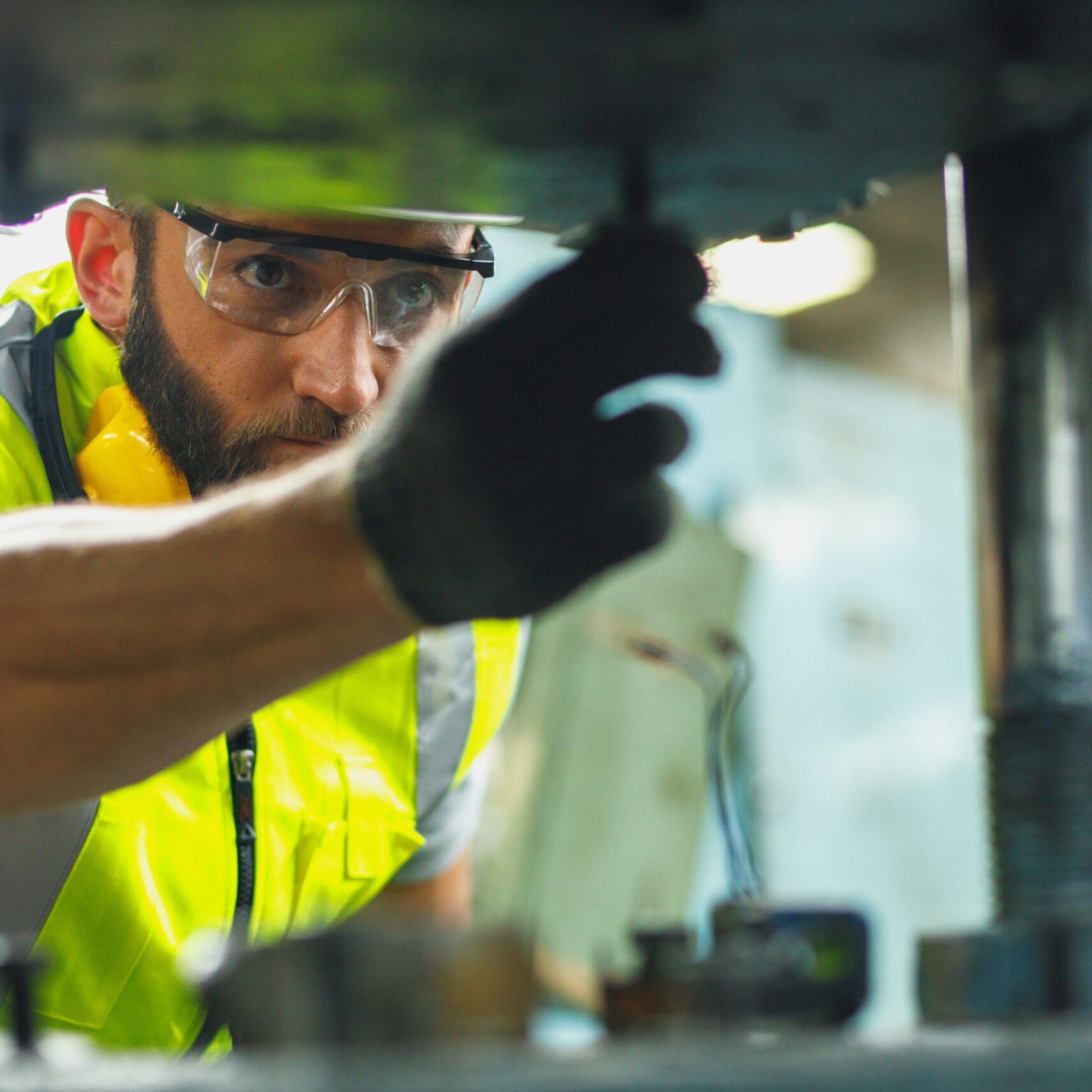 Close up hand industrial industrial plant with a tablet in hand, Engineer looking of working at industrial machinery setup in factory.