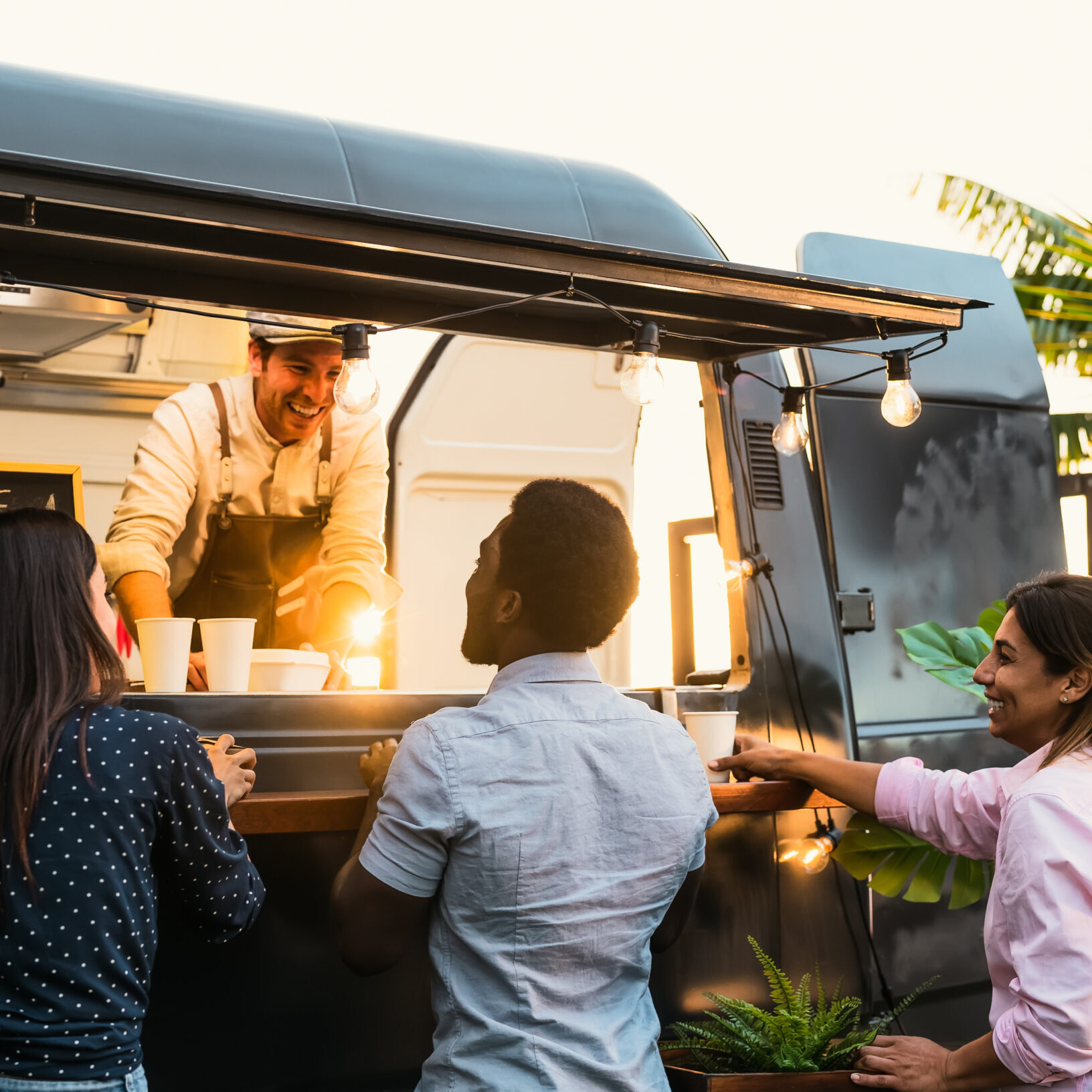 Young people buying meal from street food truck - Modern business and take away concept