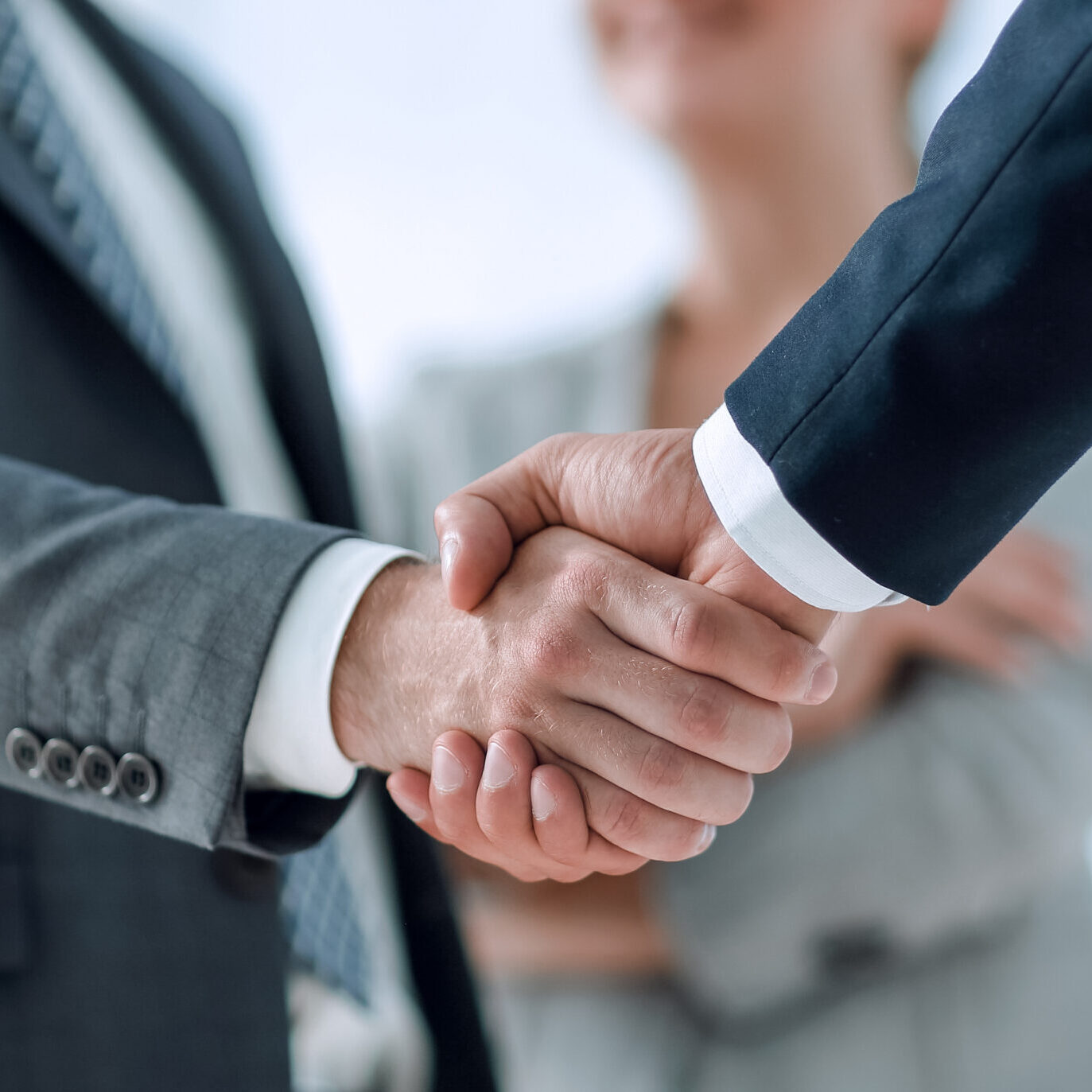 closeup of handshake of business partners on the background of business team