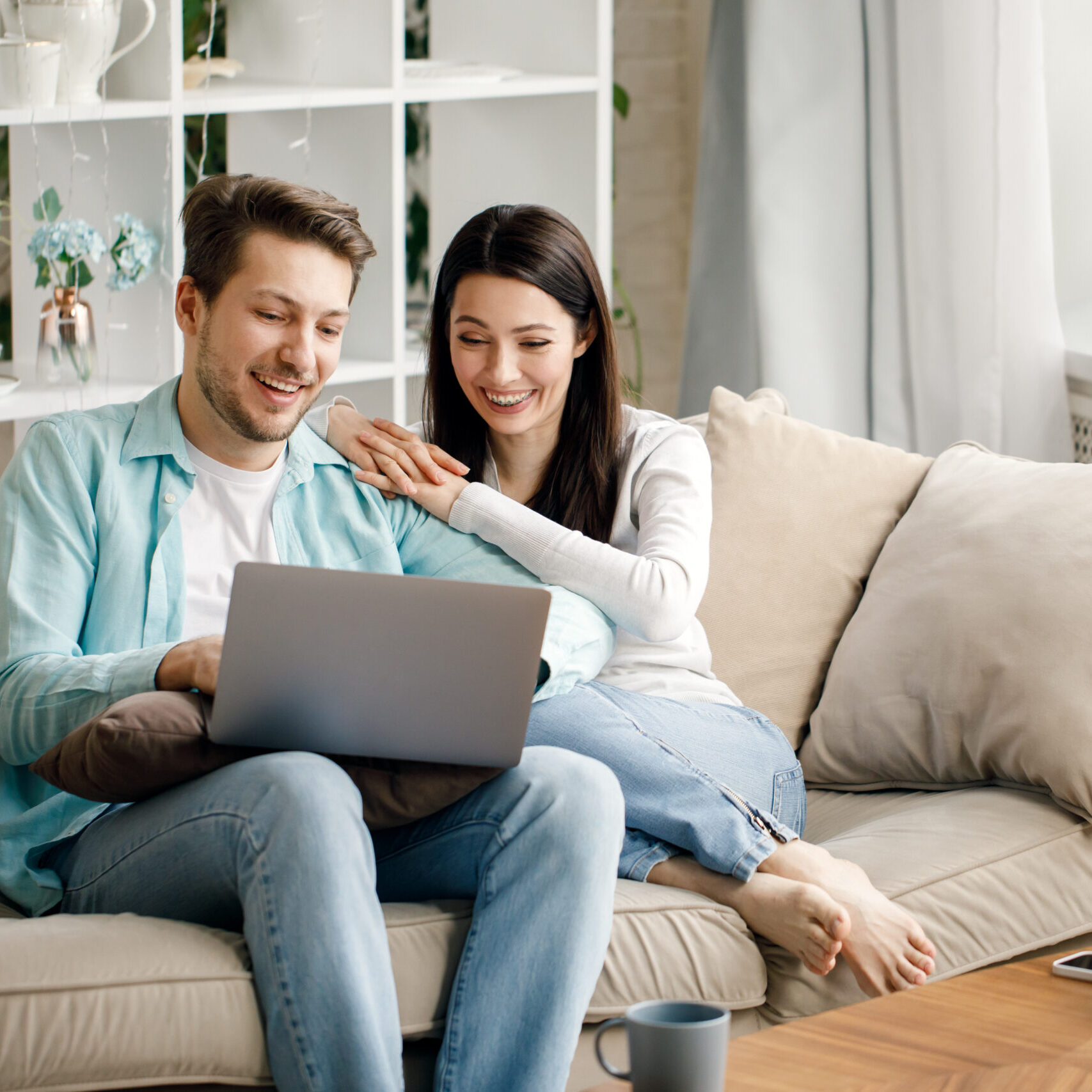 Young couple enjoy Social teleconferencing with their family via laptop screen in condominium social distancing.