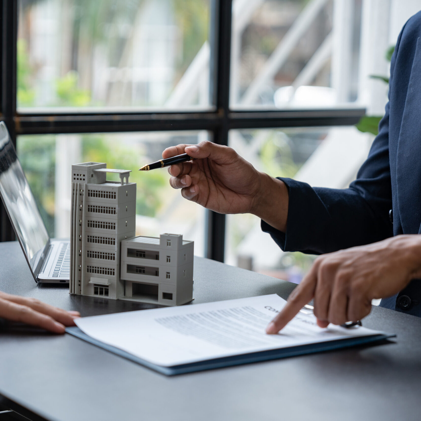 Entrepreneur, business owner, accountant, real estate agent A young Asian insurance agent explains the details of the condo purchase contract to calculate the financial risk for the client.