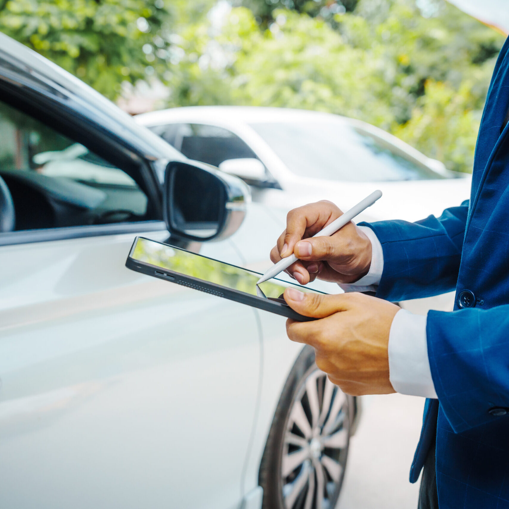 businessman in suit and car auto insurance agent assess car damage, discussing deductible, claims, coverage options comprehensive and collision insurance, completing necessary forms and appraisals.